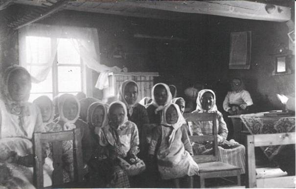image014.jpg -  Här är det kvinnosidan under en gudstjänst i Lainio i början 1930-talet förevigat av Samuli Paulaharju. Plats möjligen hos Hjalmar Henriksson, senare Skillerstedt eller alt. på Alapäägården. Stången i tak med pinnar är för att hänga ex. v blöta kläder i. Strax till vänster är öppna spisen.