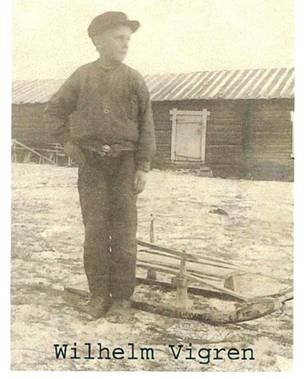 image038.jpg -  Fotograf möjligen Hallden mitten 1910-talet. Vilhelm Vigren 1901-1977 med kälke kanske för att hämta ved. Hans mor från Nikugården dog 1909. Fadern Vigren som var från Finland lämnade Lainio 1912 och gifte om sig i Tornedalen. Barnen, 3 barn, utackorderades till olika familjer i Lainio. Vilhelm kom till Juhohuset hos Johan Henrik Kruuka och Selma. Bilden utanför Juhohuset med uthusdelen bakom. Vilhelm gift med Alma Mukka från Tuollavaara. De byggde eget hus nära moderns hemställe slutet 1920-talet. Bildlån Gunnel Martti.