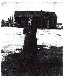image056.jpg -  Hilma Martti 1883-1976 från Marttigården gift med Hjalmar Pudas senare Skillerstedt. 1882-1950 Här står Hilma på vårvintern utanför Hilmas och Hjalmars hus byggt 1918. Innan bodde familjen i Hjalmars hemställe Alapäägården. Hilma står nära eller på landsvägen. Senare är huset påbyggt. Hilma var född i den gamla Marttigården där Laestadius missionsskola hyrde in sig. Huset brann ner slutet 1890-talet. Fotolån Christina Ericsson. Foto från 1956.