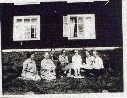 image061.jpg -  Här sitter familjen Järvfelt utanför lägenheten i Malmberget någon gång 1930-talet. Teresia med rutig klänning, till höger om henne sonen John som antagligen arbetade då i Gällivare, till höger John antagligen fästmön till John, sedan Johns syster Märta och övriga är syskon till John och Märta nämligen Hildur, Elsa samt en okänd.
