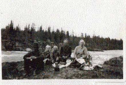 image082.jpg -  Platsen är Taanikurkio 3 km. nedströms. Det var bara Teresia av besökarna samt Karl, som fotografera, som följde med till forsen. Från vänster Levi Olla 1893-1980, Annmari Olla 1921-, Johannes Olla 1923-1998 samt Teresia 1877-1957 Forsen löper delvis i ett kanjonliknande natur. Där hade säkert Natanael sprungit som liten.