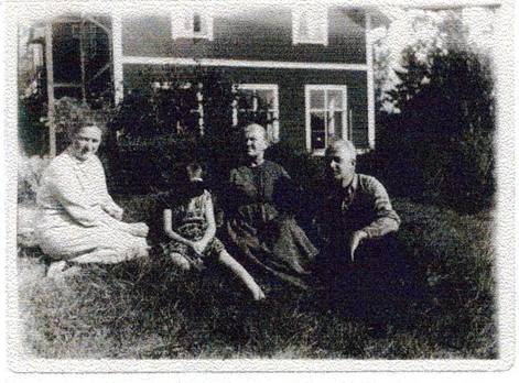image085.jpg -  Fotograf troligen Johns bror Karl Fotolån Berit Här sitter John Johansson 1891-1952 (son till Natanael) med sin mor Hilma 1861-1938 och Johns hustru Signe Nordgren 1896-1977 från Risön. Flickan är förmodligen Johns och Signes dotter Berit f. 1929. John och Signe byggde bostaden alldeles nära Johns hemställe. Huset syns bakom, Berit bor där nu (2006).
