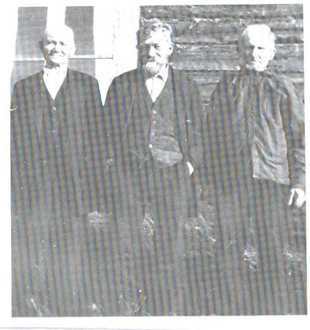 image087.jpg -  Bild från Lainioboken Tre bröder från Ollagården 1934. Från vänster Natanael Johansson 1863-1934 har kommit första gången sedan 1880 då han lämnade Ollagården för att följa med en köpman till Övertorneå för att några år senare bosätta sig i Risögrund. I mitten Isak Johansson 1861-1939 (Tarhan Iisko) boende på Tarhagården i Lainio och Erik Anders Johansson (Ollan Erkki) 1849-1936 boende på Ollagården. Erik Anders mor var Maria Holma 1818-1853 från Holmagården i Kangosfors och de övrigas mor var Johan Olofssons 1817-1891 andra hustru Anna Hansdotter 1833-1892 från Alapäägården i Lainio. Huset bakom är Ollagården ej brädfodrat än. Är 1700-talshus.