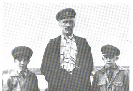 image106.jpg -  Foto Fredrik Hallden, 1929, Bild från Lainioboken Anders William Isaksson Pudas (Posti Ville) 1879-1968 står här mellan sina 2 söner. Till vänster Carl Gustaf 1921-1991 hembygdsforskare och Isak William 1919-1952 År 1910 anställdes Posti Ville att en gång varannan vecka hämta och föra post mellan Lainio och Vittangi. På sommaren användes stigen mellan Lainio och Vittangi och sedan stigen som klockaren Rautio använde när han skulle till sitt ämbete som klockare i Vittangi. Posti Ville blev lantbrevbärare 1912 och 1937 poststationsföreståndare. Lokaler hyrdes i Halldéns hall (hos sin syster) 1944 avgick han med pension och då var postlokalen förlagt i Marttigården. 1944 övertog sonen Isak postjobbet. Sedan flyttades posten till Levi Zakrissons sommarhus nära Levis bostad. Efter Isak sköttes posten av Gunhild Rova först i Levis sommarhus och sedan i Erik Uusitalos hus. Astrid Uusitalo hade hand om posten efter Gunhild. Astrid blev senare Sveriges enda kvinnliga postområdeschef tillsammans med 58 manliga kollegor. William var gift med Johanna Henriksson 1879-1950 av Marttisläktet. Det var William som av Isak Viikusjärvi (Iiskonen) köpte huset på östra sidan älven. Platsen började kallas Palo. Isak byggde huset åt hans farbror som också bar namnet Isak f. 1827 när han flyttade från Viikusjärvi till Lainio.