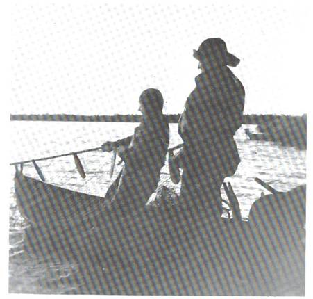 image113.jpg -  Foto Roland Henriksson, bild från Lainioboken Notdragning i Vaikkojärvi. Samuel Eriksson 1902-1980 och Axel Uusitalo 1896-1980 drar. En fiskekoja fanns där man låg över. Fiske i Vaikkojärvi förekom redan på Gustav Vasas tid. Rahtulafolket från Övertorneåtrakten (Kuivakangas) hade rättighet att fiska i sjön mot att de betalade skatt till kronan. Skatten var torkat fisk.