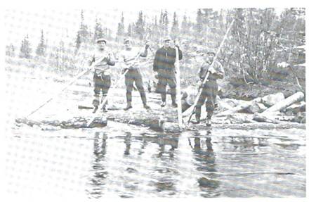 image116.jpg -  Bild från Lainioboken Flottningen var väntat av många för att tjäna lite extra pengar. Flottningen pågick normalt 1 till 2 veckor. Här i Olosjoki står på stockarna från vänster Elis Kruuka, senare Vighult, 1913-2000, Henrik Björkenvall, Hjalmar Pudas, senare Elfgren 1916-19xx och Axel Skillerstedt 1924- Olosjoki var en av de stora flottningsbäckarna i Lainio.