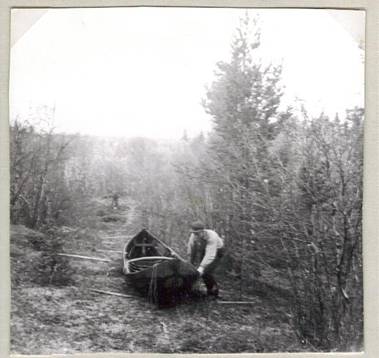 image129.jpg -  Året 1955. Här är den gamla båtdragarleden mellan Saangijoki (ovan Iisokoski) och sjön Pakajärvi. Avståndet var några 100 meter. Smala björkstänger tvärsöver fanns där sedan förut. Här är det Gunnar Eriksson som är dragare och Arne Uusitalo stod bakom kameran. Pakajärvi var en erkänd rik siksjö. I slutet 1940-talet var Isak Fredriksson 1885-1969, Samuel Eriksson 1902-1980 och sonen Gunnar till Pakajärvi för att fiska. Då var det till att staka båten från Lainio till Pakajärvi. Då användes samma led att dra båten och påfyllning med björkstänger på tvärsan gjordes. Isak berättade om de stora sikarna som han och hans föräldrar fick då omkring 1900. Vi bodde i kojan som användes vid fiske i Pakajärvi och som även kom till användning när tjärdalarna anordnades runt om sjön. Då slutet 1940-talet var sjön full med stora mörtar som Isak salta ner. Sikfångsten var av mindre omfattning. Det var skönt att komma fram till Iisokoski efter all stakning efter älven och Saangijoki. Vid Iisokoski fick man dra upp båten. Sedan var det att dra båten till Pakajärvi och ro en bit till kojan, göra eld och koka kaffe och ta en matbit innan fisket kom igång. Båtdragarleden var på samma ställe när Isak var dit i slutet 1800-talet med sina föräldrar.