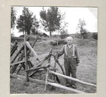 image132.jpg -  Bild 132, fotograf Arne Uusitalo, 1956 Här står Isak Gustaf Nilsson Prost (Vikusiissa) 1872-1968 vid stängslet till byn Viikusjärvi. Bakom skymtar Isaks son Lars hus.