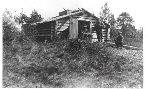 image163.jpg -  I början 1930-talet tog Samuli Paulaharju denna bild vid fiskekojan i Vaikkojärvi. Vid dörröppningen sitter Vilhelm Eriksson Mikko 1899-1971, bredvid står Vilhelms far Erik Anders Mikko 1859-1938 och pojken är Otto Elenius f. 1918 som fick följa med till fisket i Vaikkojärvi. Kojan finns kvar än 2006.