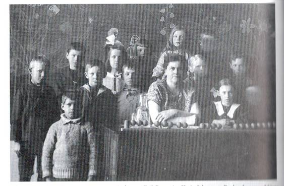 image181.jpg -  Klass 1 Centralskolan i Kiruna 1924 Bild från Folket i tiden och Kiruna kyrka 1898-1990 skriven av Gunhild Jonsson Ranestål. Längst ner och höger är Johannes Esko f. 1916 från Lainio. Familjen flyttade 1923 från Lainio till Kiruna. Föräldrarna var Johan Valter Esko f. 1893 och Hulda Pudas f. 1890. Lärarinna Hulda Bäckman med årslön 450 kr. Eskopojkarna blev kända tyngdlyftare i Kiruna.
