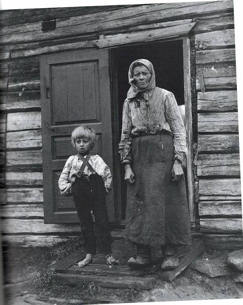 image183.jpg -  Foto Borg Mesch Kattuvuoma omkring 1914, antagligen senare än 1914 för Anna hade en son u. ä 1916-1916. Bild från Drömmen om fjällen av Hans Andersson Här står Martin Jussa sondotter Anna Maria Hansson f. 1892 med sin son vid dörröppningen till huset som ev. Martin Jussa byggde eller också är det fadern Hans Petters hus Martin Jussa var son till Greta Henriksdotter från Marttigården i Lainio och gift i Svappavaara.