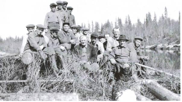 image199.jpg -  Foto Sigurd Elenius, bildlån Kjell och Bertil Elenius Flottning i Olosjoki första delen 1950-talet. Stående första pojken Birger Ericsson f. 1937. Längst nere till höger med hatten Viktor Eriksson Mikko 1905-1966 och bakom honom barhuvad Samuel Eriksson 1902-1980, Birgers far. Längst höger Samuel är Hugo Ylipää f. 1931 I mitten flottningschefen Hjalmar Fällen (barhuvad) 1886-1970 Sittande framför pojkarna fjärde från vänster Nils Henrik Olofsson Vikusjärvi, senare Björkenvall 1922-2004.