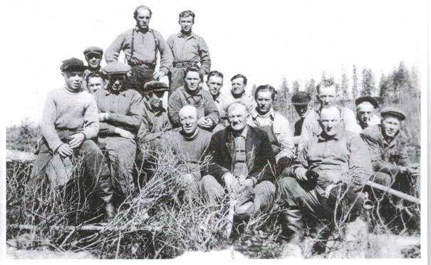 image200.jpg -  Foto ev. Sigurd Elenius kamera, han står själv stående längst vänster Bildlån Kjell och Bertil Elenius Flottning i Olosjoki första delen 1950-talet. Timret flottades normalt fram till Hukanmaa där Kangosfolket övertog flottningen. Olosjoki rinner ut i Lainioälven. Stående vänster Sigurd Elenius 1926-2003 och bredvid honom Rune Eriksson f. 1935. Sittande från vänster Birger Ericsson f. 1937, 4:e samma rad Henrik Björkenvall 1922-2004 och längst höger i samma rad Kaleb Kruuka 1915-1985 Framför Kaleb Oskar Vigren f. 1929, Längst fram från vänster Fabian Elenius 1905-1979, flottningschefen Hjalmar Fällen 1886-1970, Viktor Eriksson Mikko 1905-1966, bakom Viktor Samuel Eriksson 1902-1980, till höger Samuel John Uusitalo 1933-19xx och framför John Hugo Ylipää f. 1931.